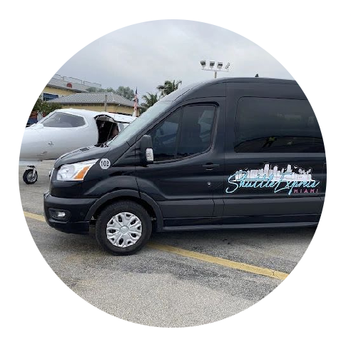 Black shuttle van parked on a lot with open hood and a private jet visible in the background. the van has "shuttle express miami" logo on the side.